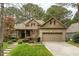 Attractive brick and stone home with mature landscaping, a two-car garage, and a welcoming front porch at 1525 Marshall Farm St, Wake Forest, NC 27587