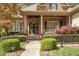 Inviting front entrance featuring stone steps, lush landscaping, and a covered porch with columns at 1525 Marshall Farm St, Wake Forest, NC 27587