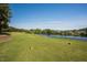 Scenic view of a well-kept golf course with a serene lake, lush trees, and green fairway at 1525 Marshall Farm St, Wake Forest, NC 27587