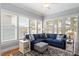 Stylish living room with a comfortable blue couch, large windows with shutters, and modern decor at 1525 Marshall Farm St, Wake Forest, NC 27587