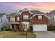 Charming two-story brick home with a well-manicured lawn and attached two-car garage at 1607 Willowcrest Rd, Durham, NC 27703