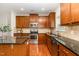 Well-equipped kitchen with a granite countertop island, stainless steel appliances and wood cabinetry at 1607 Willowcrest Rd, Durham, NC 27703