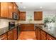 Spacious kitchen with dark wood cabinetry, granite countertops, and stainless steel appliances at 1607 Willowcrest Rd, Durham, NC 27703