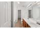 Bright bathroom with double sinks, wood cabinets, bathtub, and door to closet at 1905 Maple Sugar Ln, Fuquay Varina, NC 27526