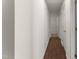 Hallway with hardwood floors featuring white walls with three doors leading to various rooms at 1905 Maple Sugar Ln, Fuquay Varina, NC 27526