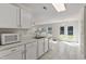 Well-lit kitchen boasting white cabinetry, stainless steel appliances and an open layout to the backyard at 1905 Maple Sugar Ln, Fuquay Varina, NC 27526