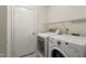 Functional laundry room equipped with a washer, dryer, shelving, and a white door at 1905 Maple Sugar Ln, Fuquay Varina, NC 27526