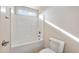 Bright, tiled bathroom with a shower/bathtub combination and transom window at 21 W Paige Wynd Dr, Angier, NC 27501