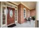 Inviting covered front porch featuring brick columns, a wooden door, and comfortable seating at 21 W Paige Wynd Dr, Angier, NC 27501