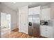 Bright kitchen featuring stainless steel refrigerator and white cabinetry with decorative crown molding at 21 W Paige Wynd Dr, Angier, NC 27501