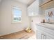 Well-lit laundry room with built-in cabinets, utility sink, and tiled flooring at 21 W Paige Wynd Dr, Angier, NC 27501