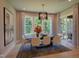 Well-lit dining area featuring a modern chandelier, large windows, and access to an outdoor space at 2108 New Hope Church Rd, Chapel Hill, NC 27514