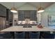 Well-appointed kitchen featuring a large island, stylish lighting, stainless steel appliances, and sleek cabinetry at 2108 New Hope Church Rd, Chapel Hill, NC 27514