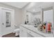 Well-lit bathroom featuring white cabinets, granite counters, and a large mirror at 211 Azalea Gaze Dr, Youngsville, NC 27596