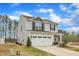 Charming two-story home with gray siding, stone accents, and a two-car garage at 211 Azalea Gaze Dr, Youngsville, NC 27596