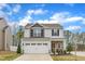 Charming two-story home with gray siding, stone accents, and a two-car garage at 211 Azalea Gaze Dr, Youngsville, NC 27596