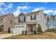 Charming two-story home with gray siding, stone accents, and a two-car garage at 211 Azalea Gaze Dr, Youngsville, NC 27596
