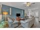 Comfortable living room boasts gray furniture, an accent wall, and great natural light at 211 Azalea Gaze Dr, Youngsville, NC 27596
