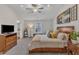 Comfortable main bedroom featuring a ceiling fan, wooden bed frame, and neutral decor at 211 Azalea Gaze Dr, Youngsville, NC 27596