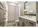 Bright bathroom features a shower-tub combo, gray vanity with white countertop, and gray tile flooring at 215 Bonterra Way, Chapel Hill, NC 27516