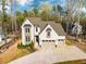 Aerial view of a home with a large driveway, brick facade, and surrounding green landscape at 215 Bonterra Way, Chapel Hill, NC 27516