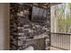 Outdoor fireplace with a stone surround and mounted television at 215 Bonterra Way, Chapel Hill, NC 27516