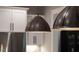 Dual dome-shaped metal pendant lights with stainless steel appliances and white cabinetry at 215 Bonterra Way, Chapel Hill, NC 27516