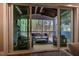 Through sliding glass doors, experience this inviting covered patio featuring stone fireplace and wooded scenery at 215 Bonterra Way, Chapel Hill, NC 27516