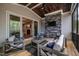 Relaxing covered patio with a stone fireplace, comfortable seating, and a wood ceiling at 215 Bonterra Way, Chapel Hill, NC 27516