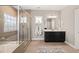 Bright bathroom featuring a soaking tub, frameless shower, and dark vanity with a white countertop at 216 Ocean Jasper Dr, Holly Springs, NC 27540