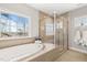 Relaxing bathroom with soaking tub, frameless shower, and a large window with a private view at 216 Ocean Jasper Dr, Holly Springs, NC 27540