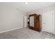 Neutral-toned bedroom with a decorative armoire, soft carpet, and plenty of natural light at 216 Ocean Jasper Dr, Holly Springs, NC 27540