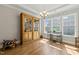 Elegant dining space featuring hardwood floors, large windows, and a charming display cabinet at 216 Ocean Jasper Dr, Holly Springs, NC 27540