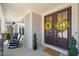 Inviting front porch with rocking chairs and double doors adorned with cheerful yellow wreaths at 216 Ocean Jasper Dr, Holly Springs, NC 27540