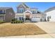Attractive two-story home featuring a charming front porch, well-maintained lawn, and three-car garage at 216 Ocean Jasper Dr, Holly Springs, NC 27540