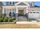 Charming front porch with stone accents and a decorative double-door entrance at 216 Ocean Jasper Dr, Holly Springs, NC 27540