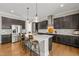 Spacious kitchen boasts a center island with bar stools, stainless steel appliances, and hardwood floors at 216 Ocean Jasper Dr, Holly Springs, NC 27540