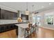 Modern kitchen features a large island with seating, dark cabinets, and stainless steel appliances at 216 Ocean Jasper Dr, Holly Springs, NC 27540
