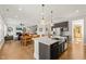 Open concept kitchen with a large island and stainless steel appliances flows into the living and dining area at 216 Ocean Jasper Dr, Holly Springs, NC 27540