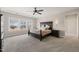Serene main bedroom with tray ceilings, a ceiling fan, large windows, and soft carpet flooring at 216 Ocean Jasper Dr, Holly Springs, NC 27540