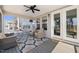 Inviting screened porch with comfortable seating, ceiling fan, rug and view of the backyard at 216 Ocean Jasper Dr, Holly Springs, NC 27540
