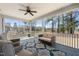 Relaxing screened porch with comfortable seating, ceiling fan, rug and view of the trees at 216 Ocean Jasper Dr, Holly Springs, NC 27540