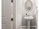 Charming powder room with pedestal sink, decorative mirror, and neutral paint at 216 Ocean Jasper Dr, Holly Springs, NC 27540