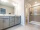 Bathroom featuring grey vanity with double sinks and a glass door shower at 2456 Tonoloway Dr, Raleigh, NC 27610
