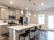 Modern kitchen features a large island with bar seating, stainless steel appliances, and stylish pendant lights at 2456 Tonoloway Dr, Raleigh, NC 27610