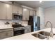 Close-up view of kitchen showcasing stainless appliances, gray cabinetry, and modern fixtures at 2456 Tonoloway Dr, Raleigh, NC 27610