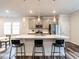 Contemporary kitchen showcasing island seating, stainless appliances, gray cabinets, and modern lighting fixtures at 2456 Tonoloway Dr, Raleigh, NC 27610