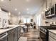 Stylish kitchen featuring quartz countertops, stainless appliances, gray cabinets, and open floorplan to living area at 2456 Tonoloway Dr, Raleigh, NC 27610
