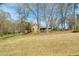 Brick home surrounded by mature trees in a lush setting, showcasing its serene location at 2746 Moss Creek Loop, Elon, NC 27244