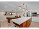 Open concept kitchen with white cabinets, stainless steel appliances, an island, and pool table area at 2746 Moss Creek Loop, Elon, NC 27244